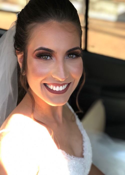 Noiva sorrindo, com véu, penteado e maquiagem do Cirs Salão de Beleza